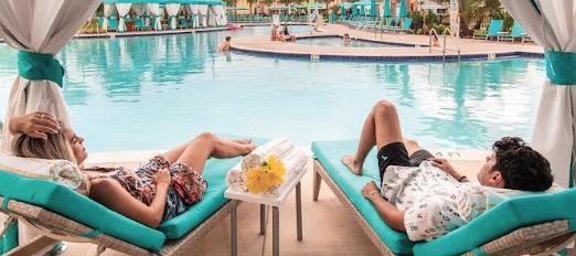Couple relaxing in a private cabana beside a pool